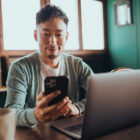 Man on his phone with a laptop