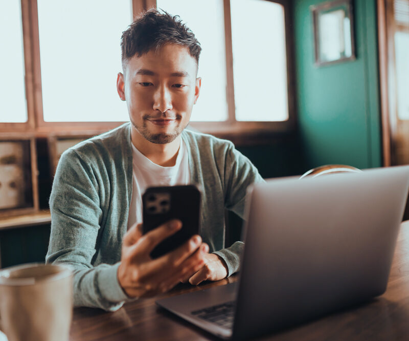 Man on his phone with a laptop