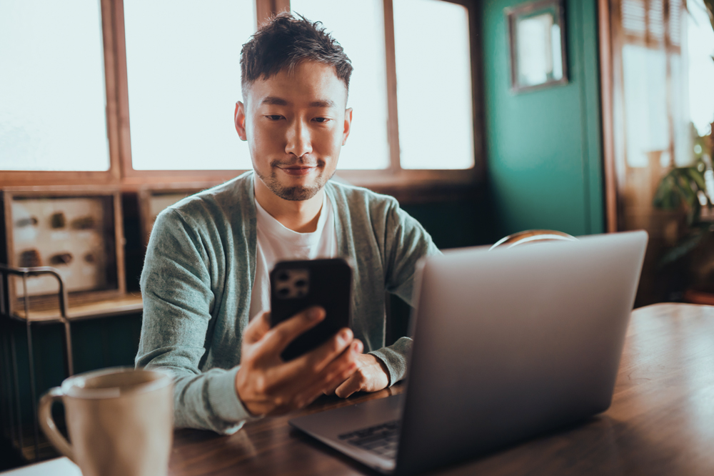 Man on his phone with a laptop