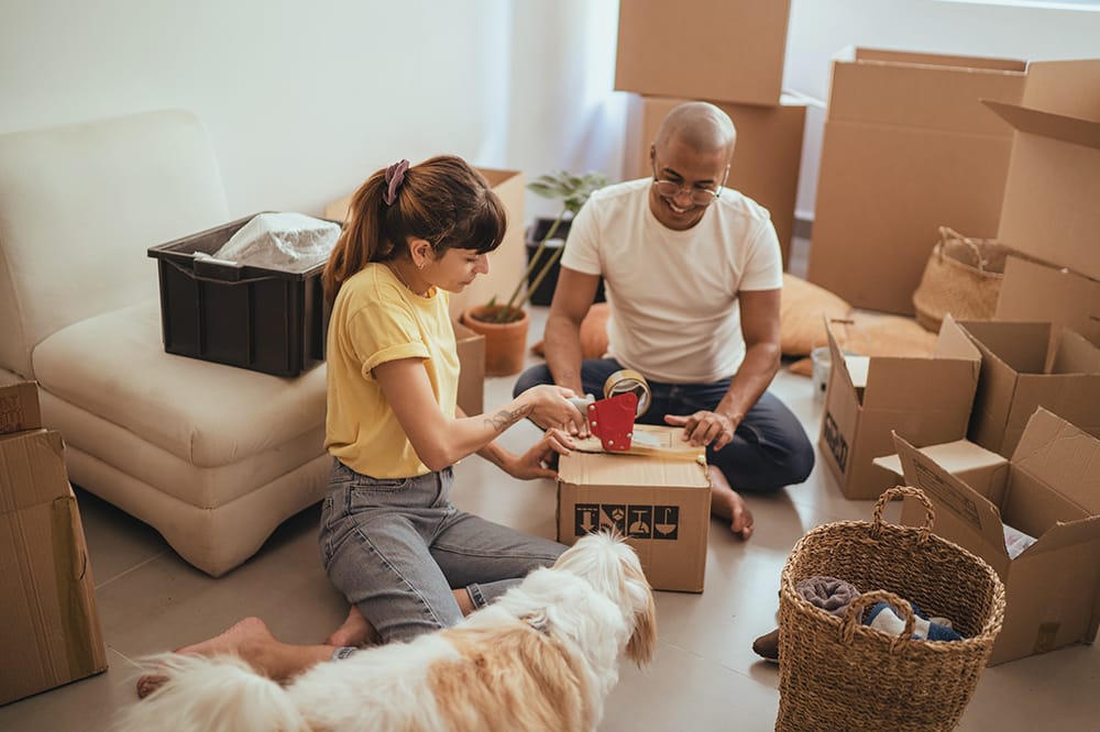 Couple taping moving boxes