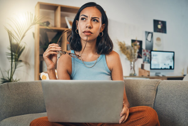 woman pondering a though while working on the computer